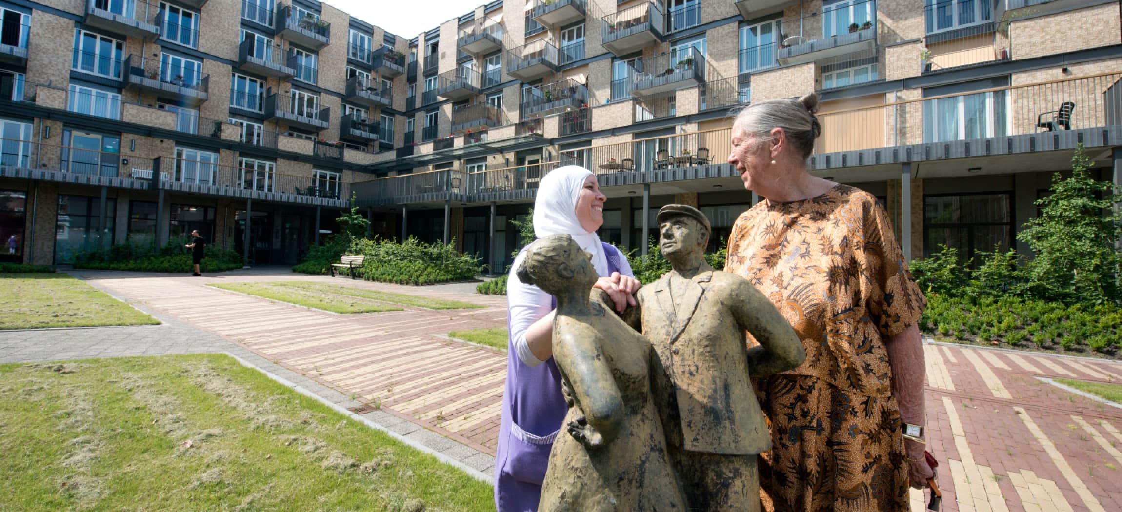 Stadse binnentuin met standbeeld en 2 vrouwend