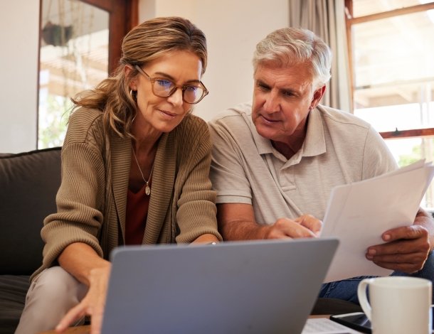Twee vrouwen aan tafel met kopje koffie, de jongere vrouw houdt documenten vast en praat