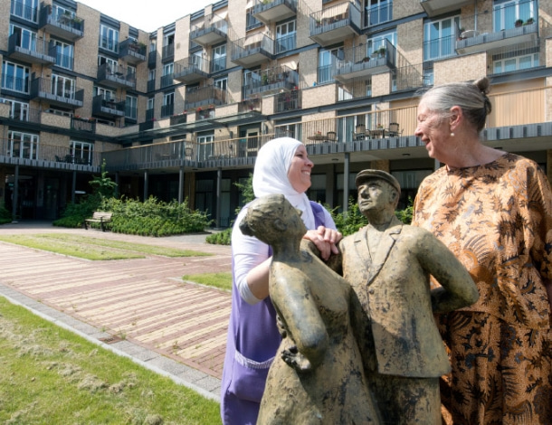 Stadse binnentuin met standbeeld en 2 vrouwend